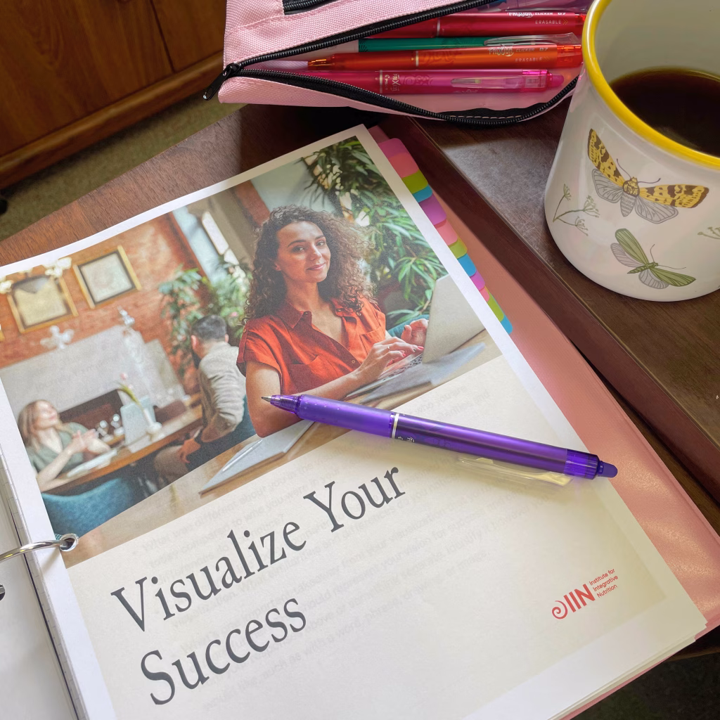 Handwritten notes, pencil case, and cup of tea during a study session for becoming a health coach while still healing